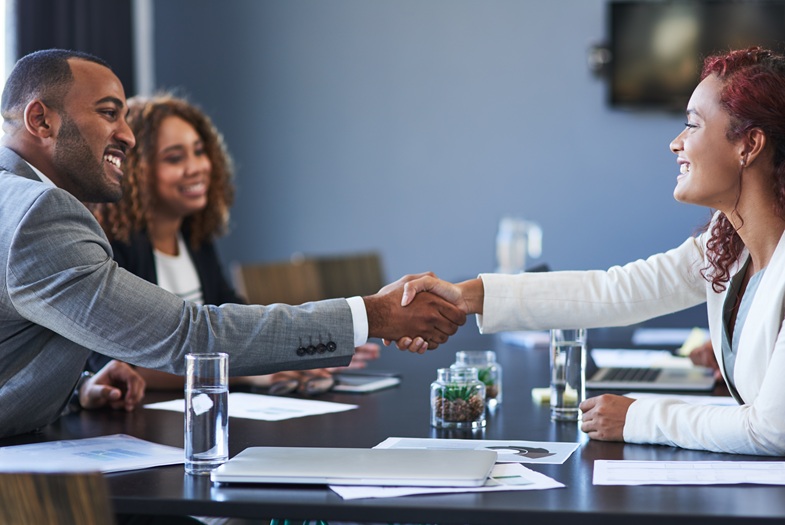 Sealing the deal with a handshake. Cropped shot of two young businesspeople shaking hands during a meeting in the boardroom.